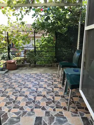 a patio with a stone floor with two chairs and a table at Нощувки Пловдив Тепето Plovdiv Hill in Plovdiv