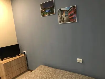 a bedroom with a bed and a tv on a wall at Нощувки Пловдив Тепето Plovdiv Hill in Plovdiv