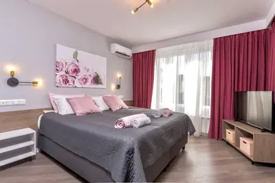 a bedroom with a large bed and a television at ROSÉ one bedroom designer apartment in city centre by Flat Mаnager in Sofia