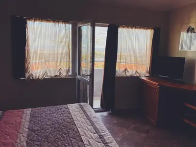 a bedroom with a bed and a sliding glass door at Hotel Fancy in Sofia