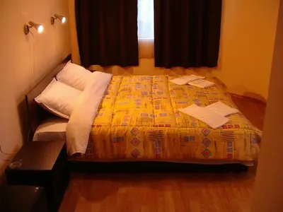 a bedroom with a bed with a yellow comforter at МОТЕЛ СИТИ с БЕЗПЛАТЕН ПАРКИНГ in Plovdiv