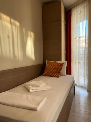 a bed with two towels on it in a room at Хостел Атлас - Hostel Atlas in Blagoevgrad