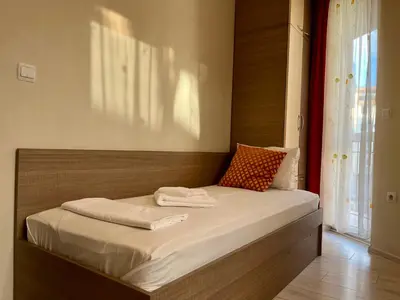 a bedroom with a large bed with a wooden headboard at Хостел Атлас - Hostel Atlas in Blagoevgrad