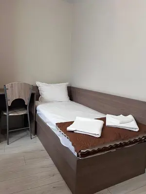 a bedroom with a bed with two towels on it at Хостел Атлас - Hostel Atlas in Blagoevgrad
