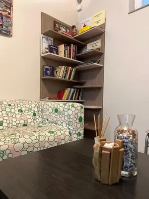 a living room with a couch and a book shelf at Хостел Атлас - Hostel Atlas in Blagoevgrad