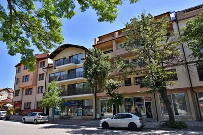 a building with cars parked in front of it at City Apartments in Velingrad