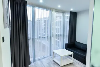 a living room with a couch and a large window at Стаи за гости Десита in Blagoevgrad