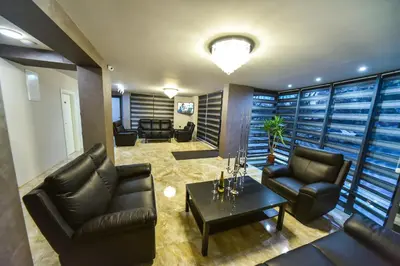 a living room with leather chairs and a table at Стаи за гости Десита in Blagoevgrad