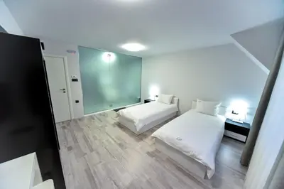 a small bedroom with two beds and a mirror at Стаи за гости Десита in Blagoevgrad
