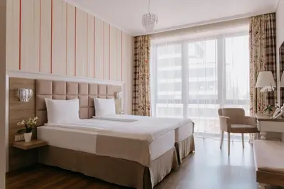 a bedroom with a large bed and a large window at Impresamente Art Hotel in Sofia