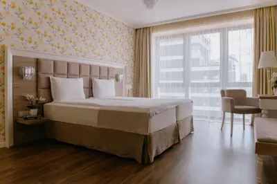 a bedroom with a large bed and a table and chairs at Impresamente Art Hotel in Sofia