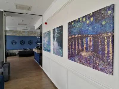 a hallway with several large paintings on the wall at Impresamente Art Hotel in Sofia
