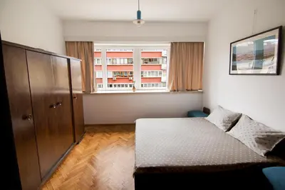 a bedroom with a bed and a large window at Design Apartment in Sofia top city center in Sofia