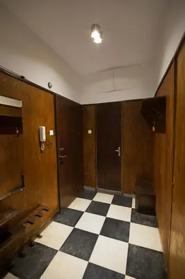 a room with wooden doors and a checkered floor at Design Apartment in Sofia top city center in Sofia