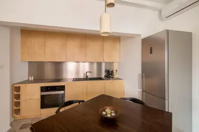 a kitchen with a wooden table and a refrigerator at Design Apartment in Sofia top city center in Sofia