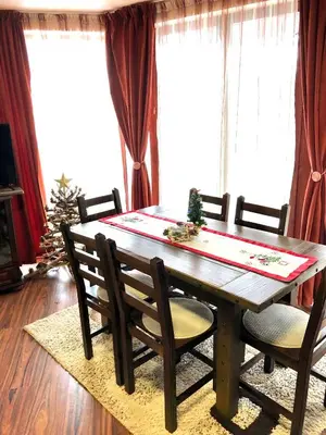 a dining room table with chairs and a christmas tree at Pamporovo Villa in Pamporovo