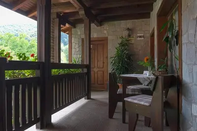 a porch of a house with a table and a door at СТАР МЕРАК in Ribarica