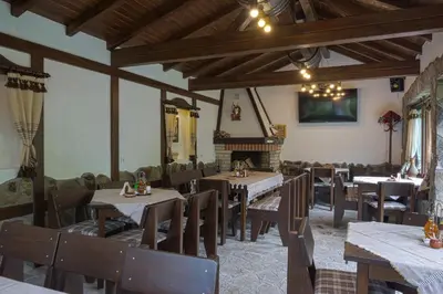 a dining room with tables and chairs and a fireplace at СТАР МЕРАК in Ribarica