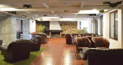 a waiting room with leather chairs and a fireplace at VIVA Flora apartment 607A in Borovets