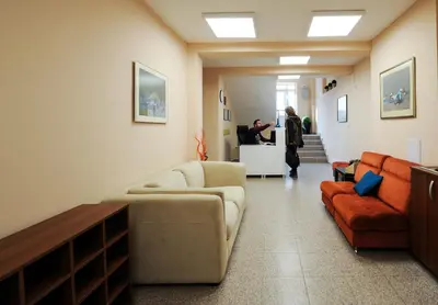 a lobby with a couch and chairs and a person standing at a counter at Best Rest Guest Rooms in Plovdiv
