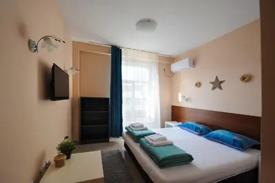 a bedroom with a bed with blue pillows on it at Best Rest Guest Rooms in Plovdiv