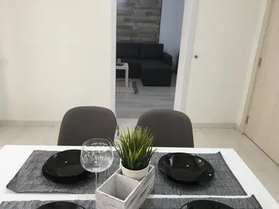 a dining room table with black plates and chairs at Апартамент Рози in Sandanski