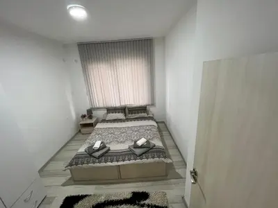 a bedroom with a bed with two pillows on it at Апартамент Рози in Sandanski