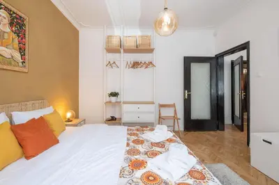 a bedroom with a large white bed with orange pillows at Sophisticated Gem with Private parking in Sofia