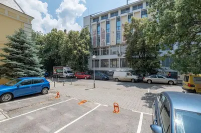 a parking lot with cars parked in front of a building at Sophisticated Gem with Private parking in Sofia