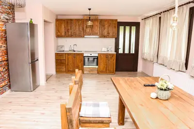 a kitchen with a wooden table and a refrigerator at Villa Kashtata in Resilovo