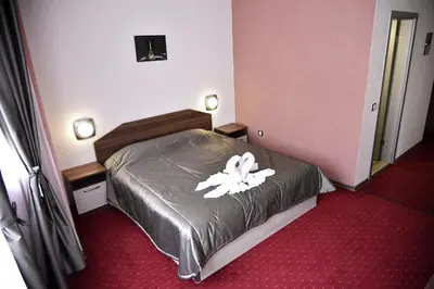 a hotel room with a bed with a white flower on it at NAYS in Madan