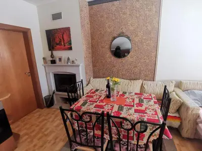 a dining room with a table and a couch at Ски апартамент, студио Хрис, Лъки Пампорово in Pamporovo