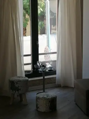 a room with a window with a table and two stools at Casa Lavenda in Plovdiv