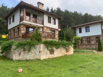 a house with a balcony on top of a stone wall at Планински кът in Dorkovo