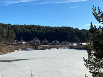 a frozen lake in front of some houses at Планински кът in Dorkovo