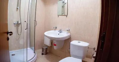 a bathroom with a toilet and a sink and a shower at Two bedroom apartments in Murphys Lodge in Bansko