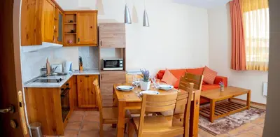 a kitchen and dining room with a table and a kitchen and a dining room at Two bedroom apartments in Murphys Lodge in Bansko