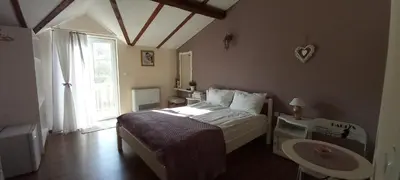 a bedroom with a bed and a table and a window at Къща за гости DANI DREAM in Sapareva Banya