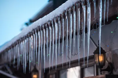 a fence covered in icicles with snow on it at NEXT TO GONDOLA Stylish and Charming apartment in Bansko