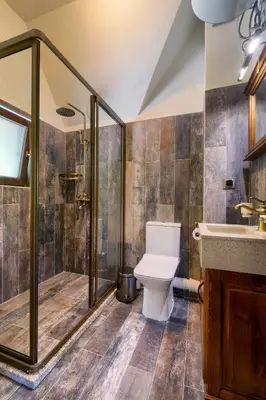 a bathroom with a toilet and a shower and a sink at Hotel Apostolite in Sandanski