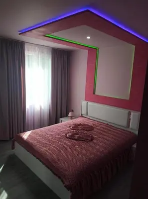 a bedroom with a red bed with a large mirror at ВИЙГ in Sapareva Banya