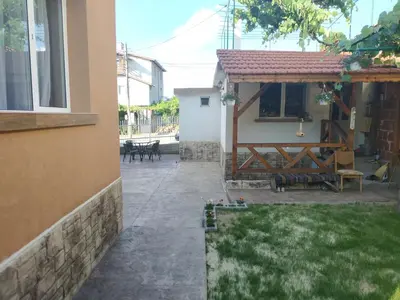 a patio of a house with a bench and a table at ВИЙГ in Sapareva Banya