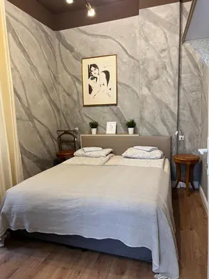 a bedroom with a large bed with a wall at 4us - 24h Self Check-in in Sofia