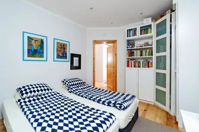 two beds in a room with a book shelf at 3BDR The Hadjis - City Center Flat in Sofia
