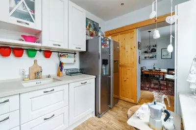 a kitchen with white cabinets and a stainless steel refrigerator at 3BDR The Hadjis - City Center Flat in Sofia