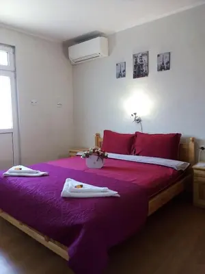 a bedroom with a purple bed with towels on it at Holiday guest house KEMO in Sapareva Banya