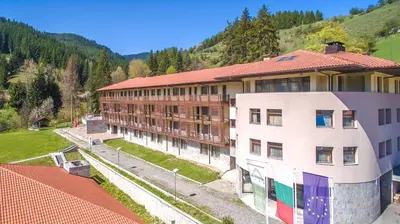 a building with a mountain in the background at Borika Hotel in Chepelare