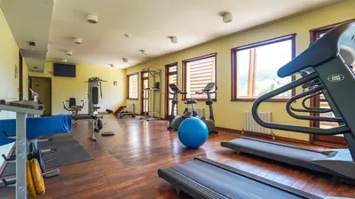 a gym with several treadmills and exercise machines at Borika Hotel in Chepelare