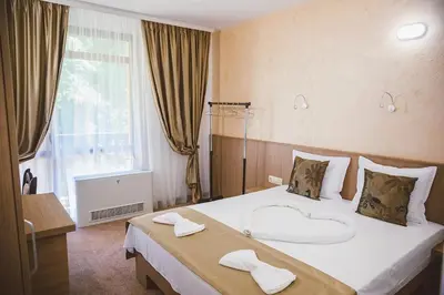 a hotel room with a large bed with towels on it at Стаи за гост Хит Хаус и СПА in Bratsigovo
