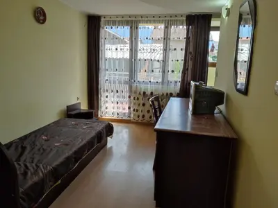 a bedroom with a bed and a desk and a window at Къща за гости M-Stone in Bansko